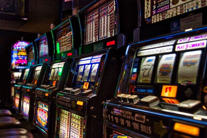Row of illuminated slot machines inside a Las Vegas casino.