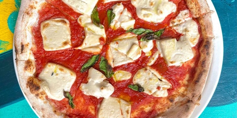 Checking out a neighborhood pizza spot while planning a flexible vegan travel day in Cape Town