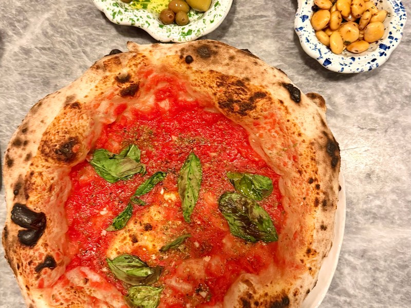 Vegan spread at Una Pizza Napoletana featuring marinara pizza, olives, lupini beans