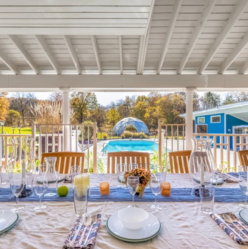 Outdoor table with pool and biodiome at Little Logan’s Farm